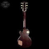 A dark brown electric guitar shown from the back against a solid black background, featuring a glossy finish, gold hardware, and a visible Tone Shop watermark in the top-left corner.