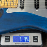 Blue electric guitar on a digital scale displaying weight