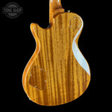 The back of an electric guitar with a glossy flamed maple wood finish, featuring a white inlay along the body edge, shown against a solid black background.