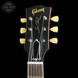 Close-up of a Gibson Les Paul Jr. electric guitar headstock in black with gold lettering, cream tuning pegs, and silver tuning keys, shown against a black background with a Tone Shop watermark in the top left.