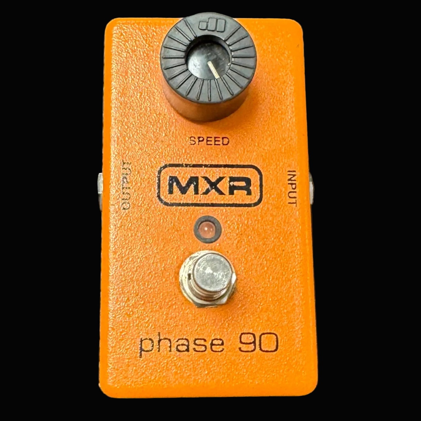 Orange MXR phase 90 guitar effects pedal on a textured surface