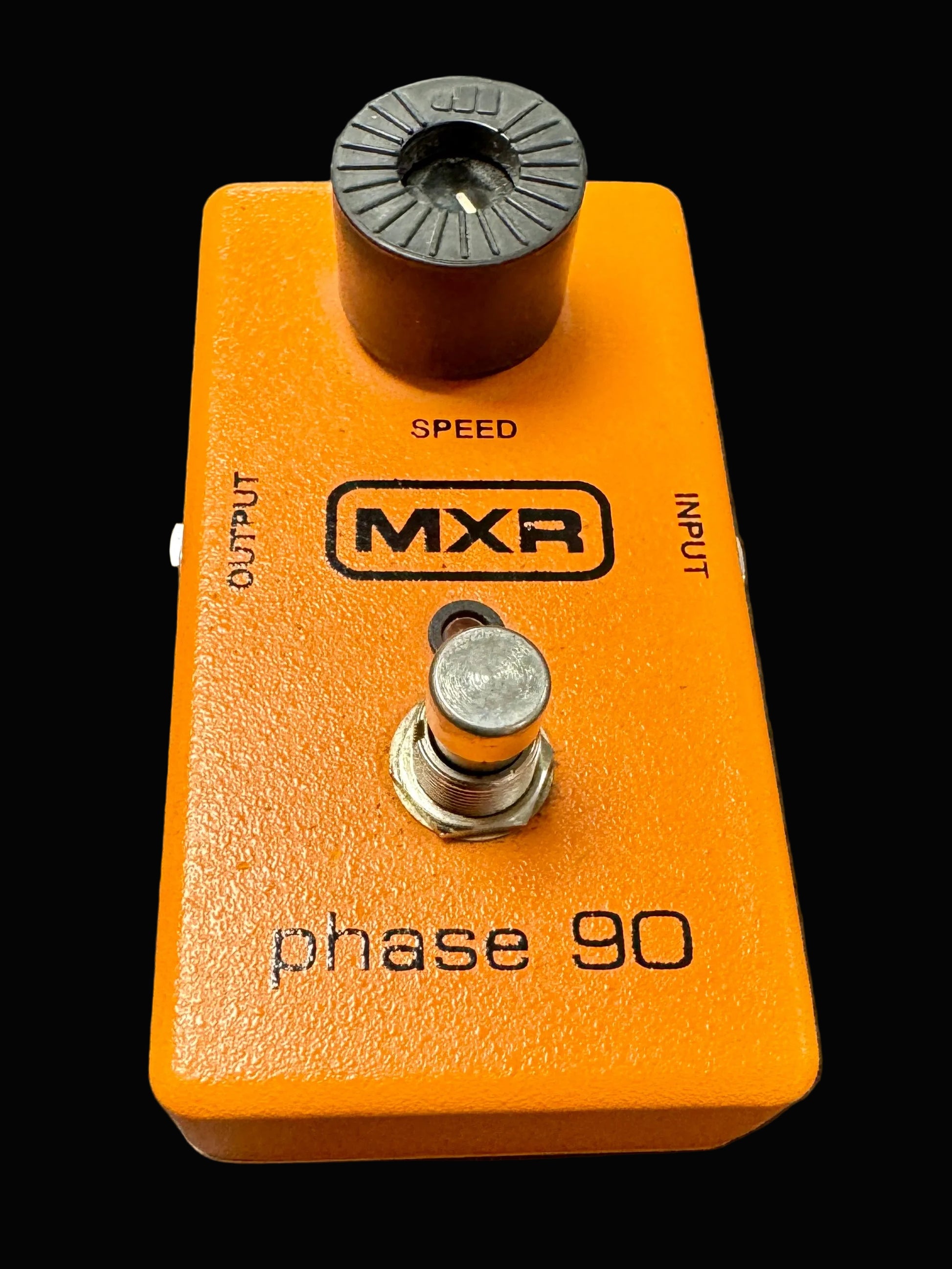 Orange MXR phase 90 guitar effects pedal on a textured surface