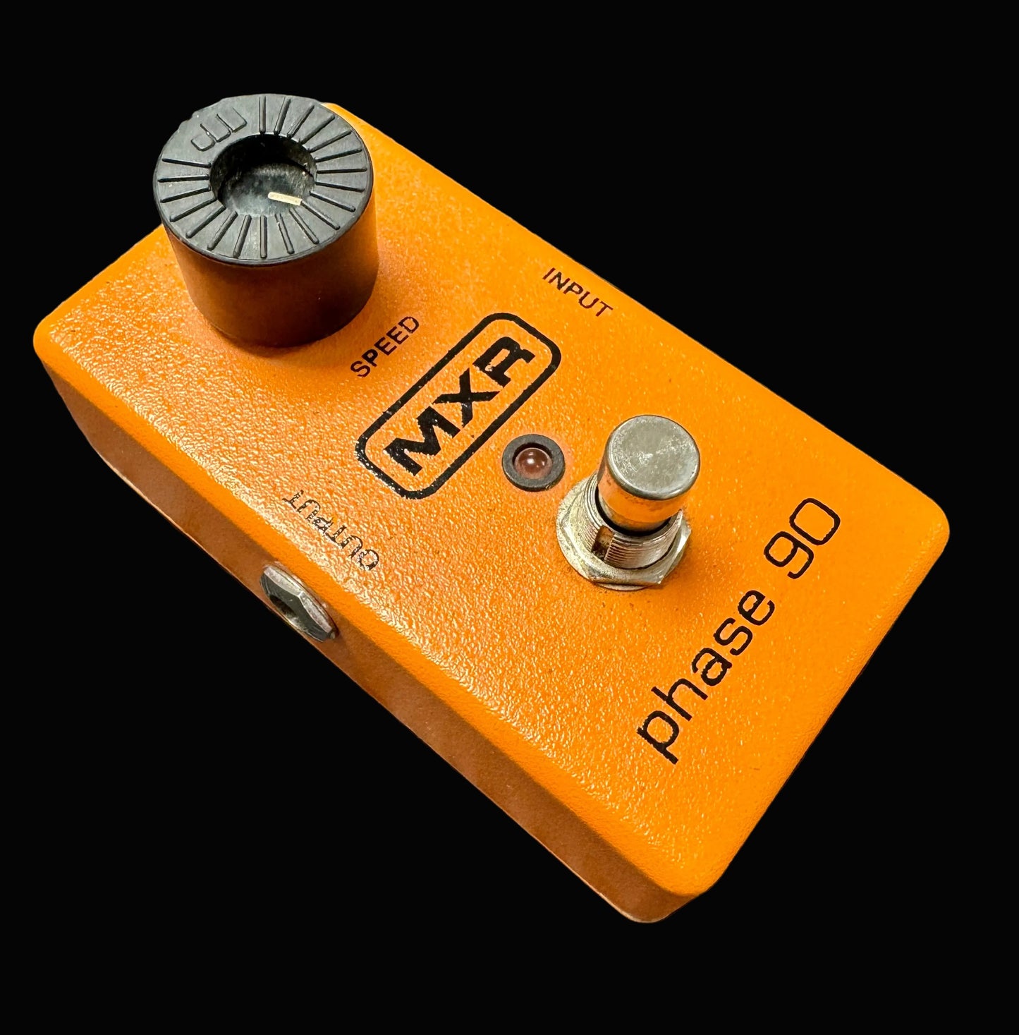 Orange MXR Phase 90 guitar effects pedal on a textured surface