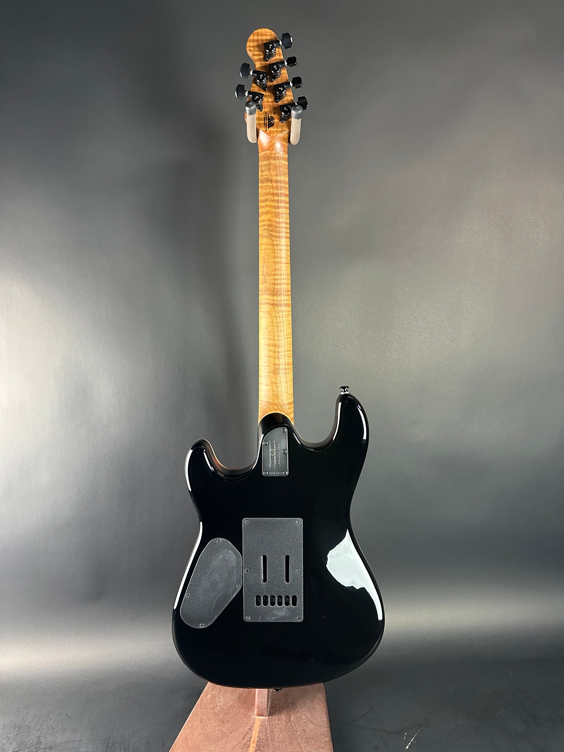 Black electric guitar on a gray background