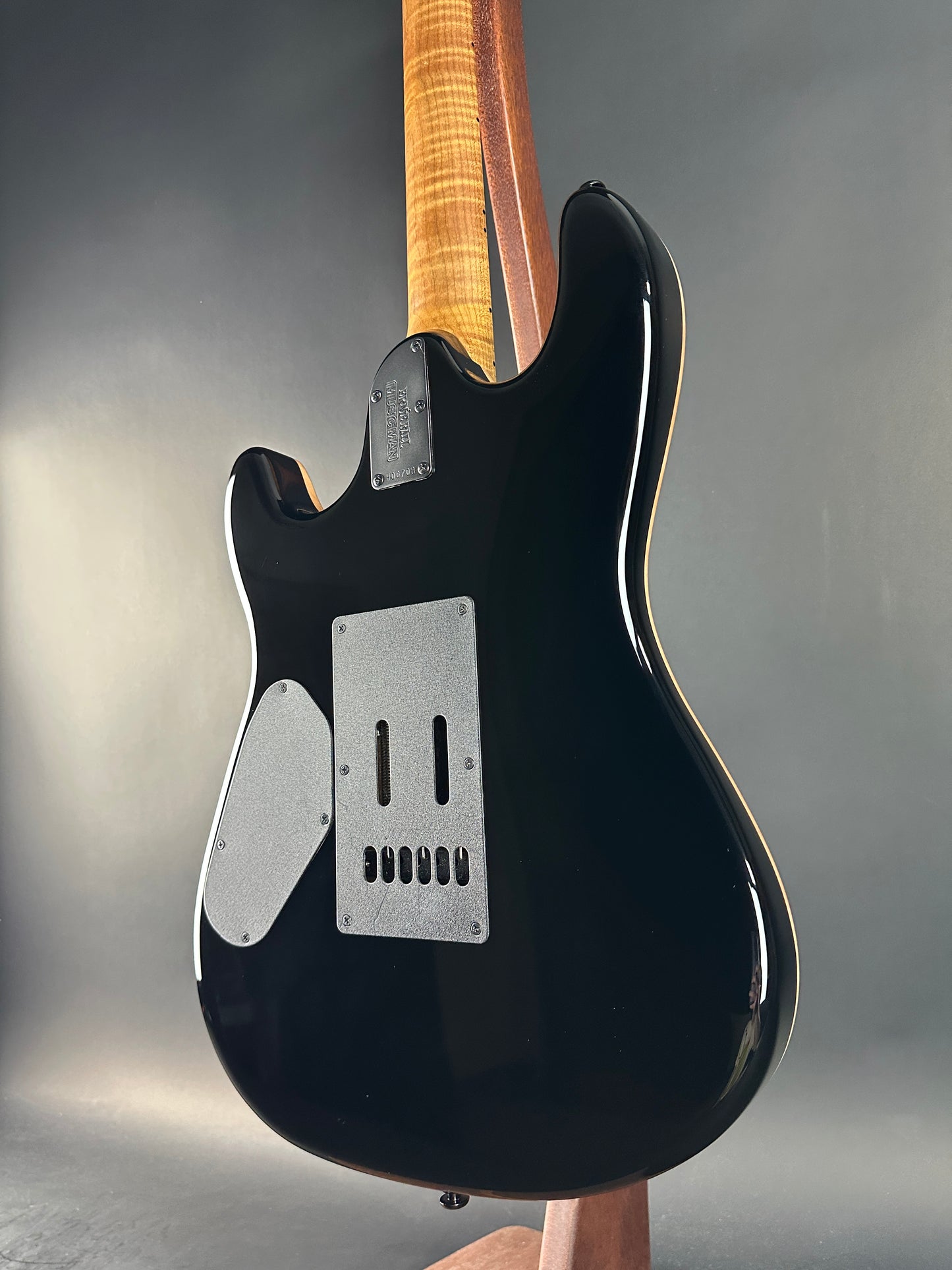 Black electric guitar on a gray background