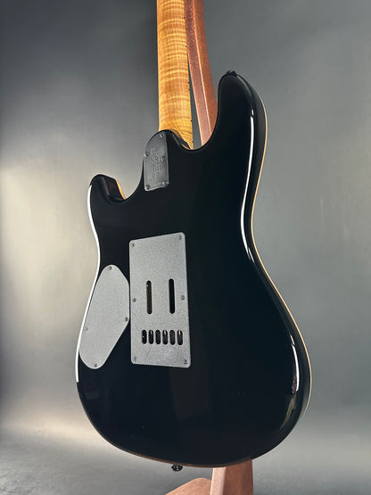 Black electric guitar on a gray background
