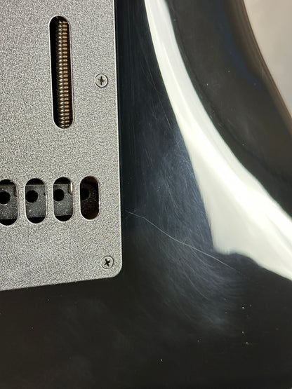 Close-up of a metallic panel with screw holes and a textured surface.