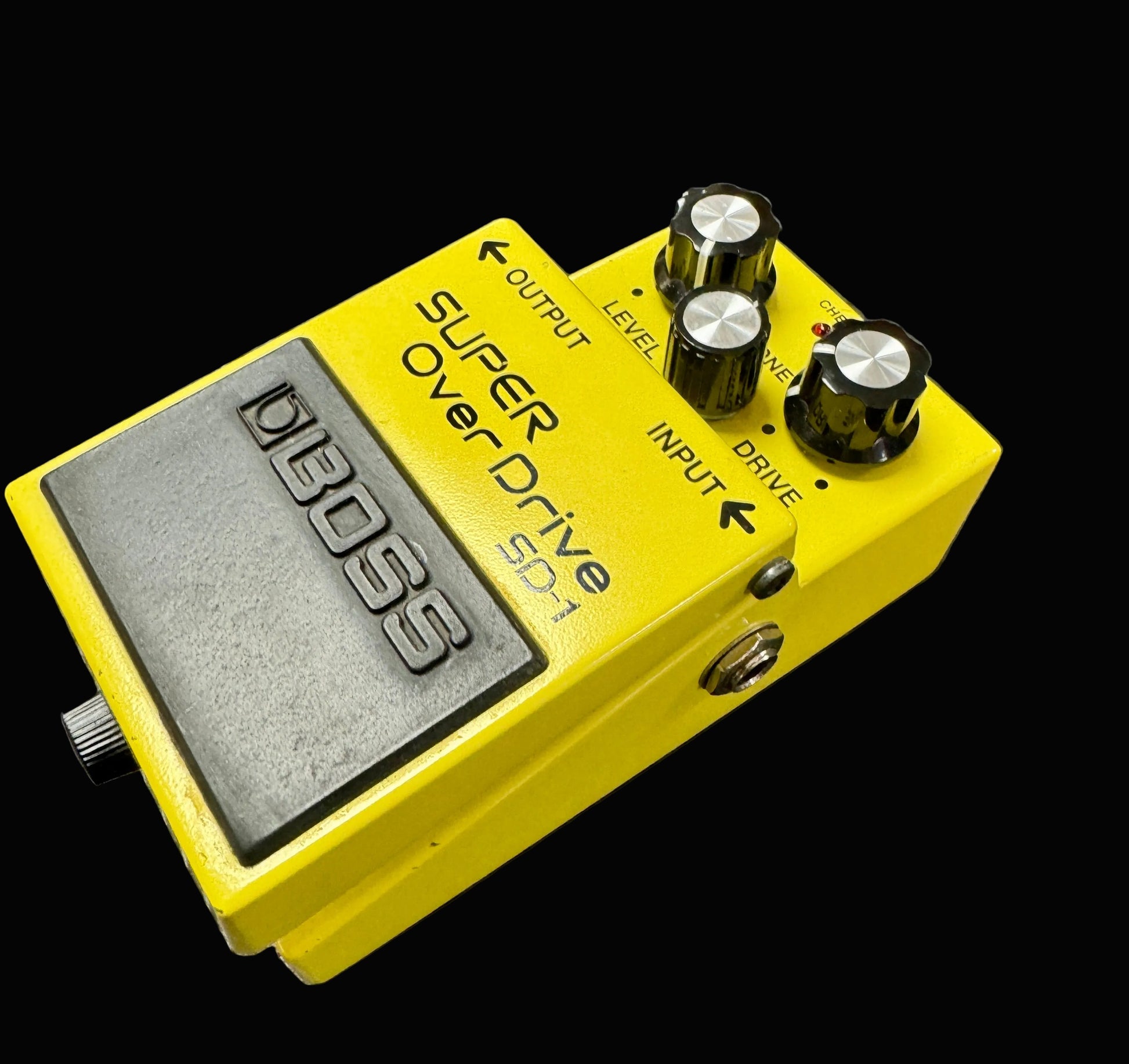 Yellow Boss Super Overdrive pedal on a textured surface