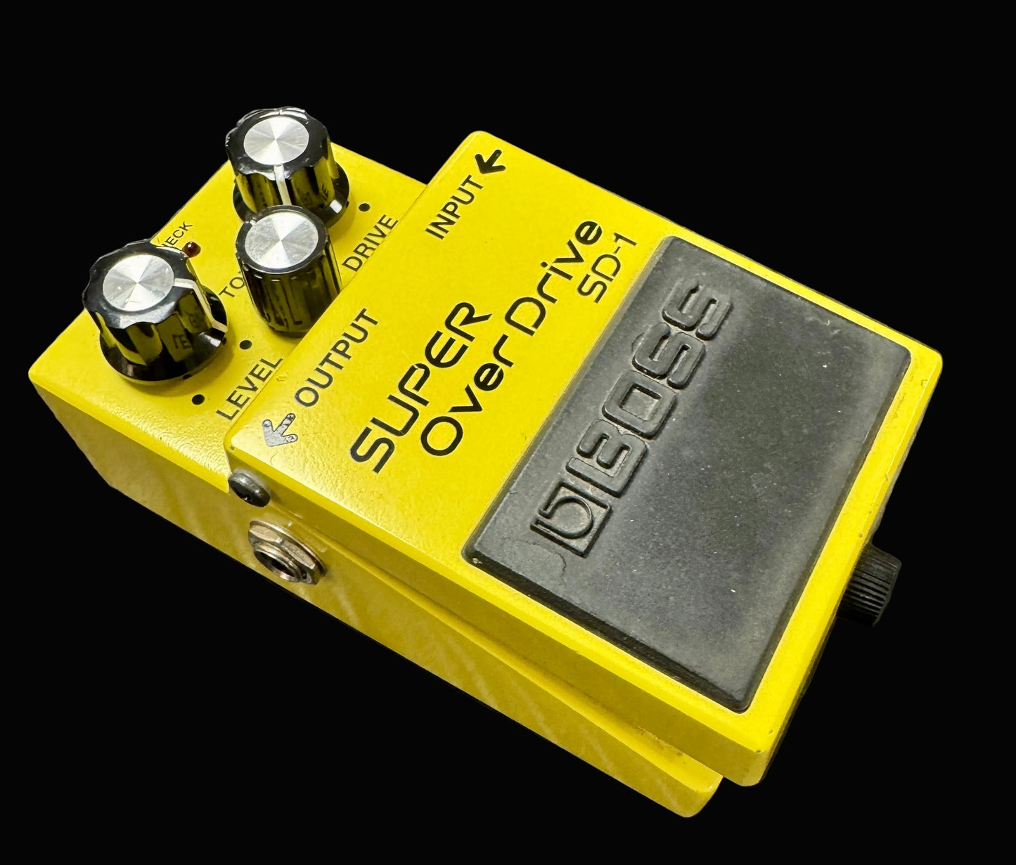 Yellow Boss Super Overdrive pedal on a textured surface