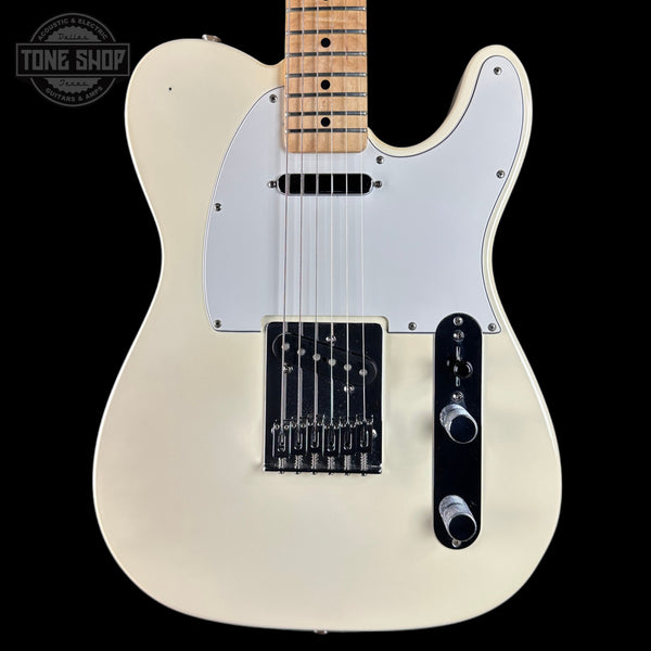 White electric guitar with a black pickguard on a black background, featuring 'Tone Shop' branding.