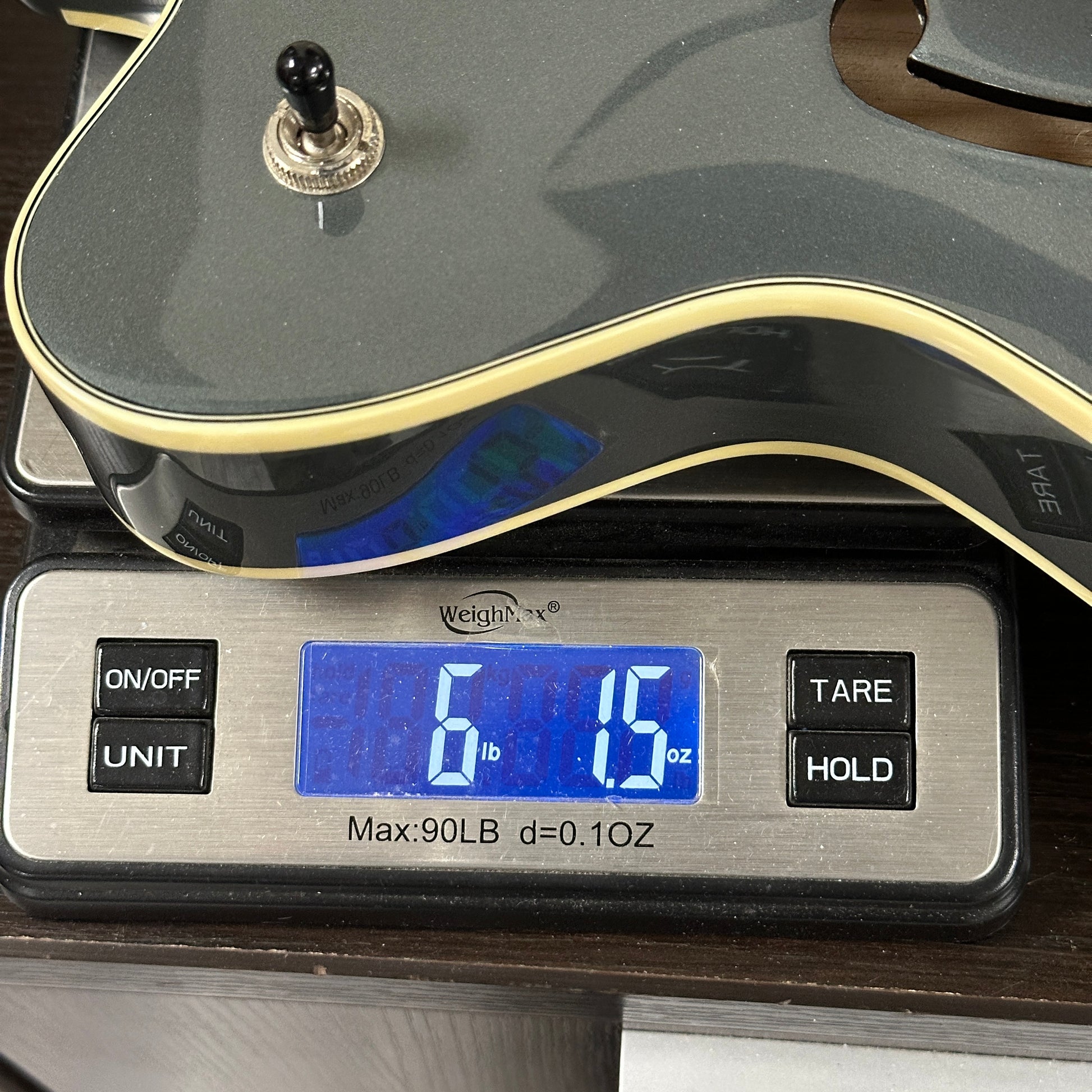Digital scale displaying weight with a guitar on top