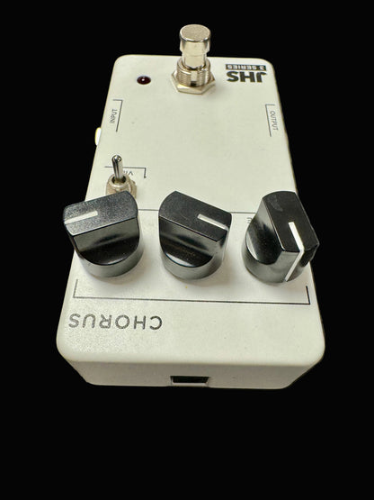 Guitar effects pedal with three knobs on a textured surface