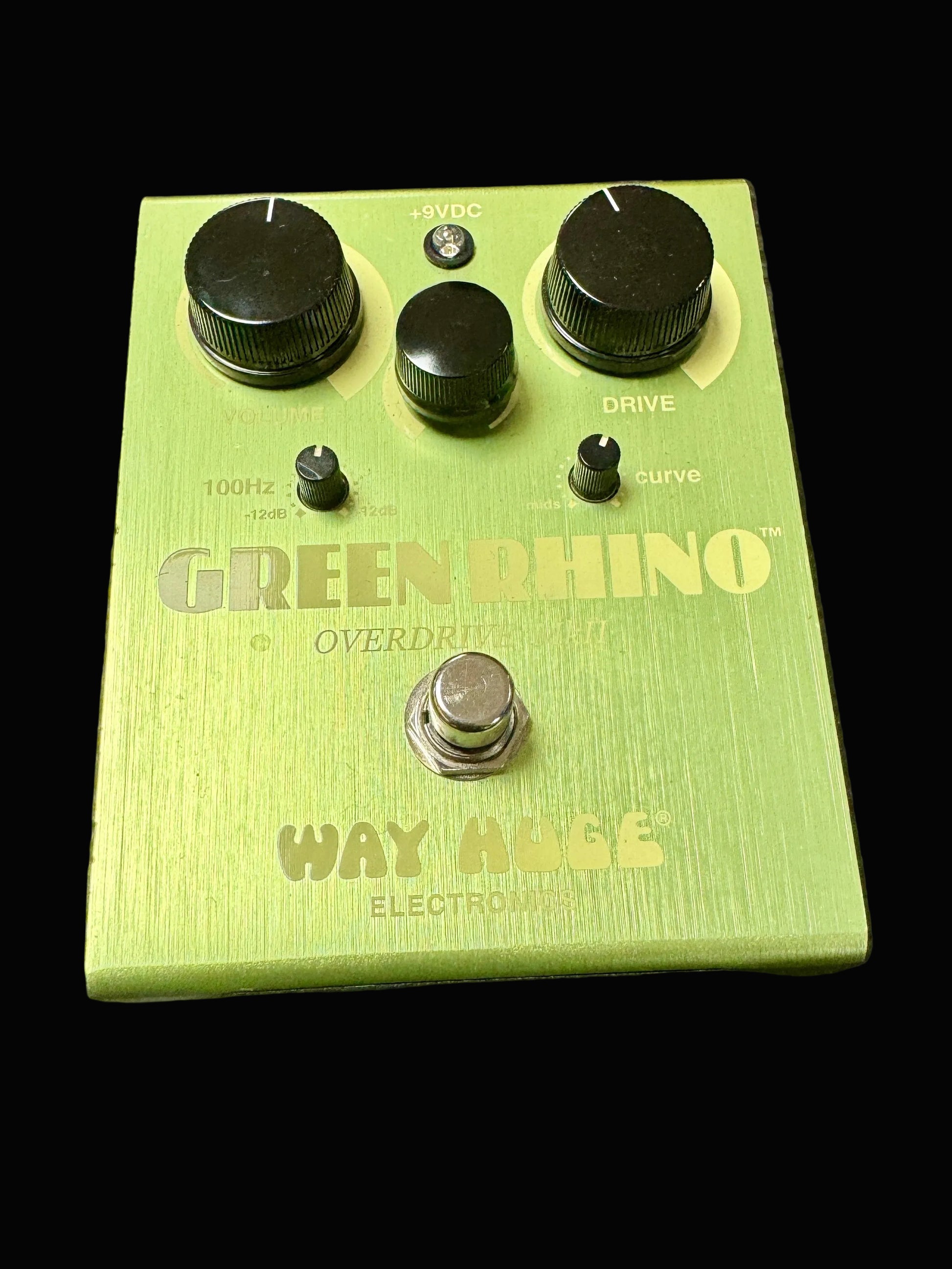 Green guitar effects pedal with 'Green Rhino' and 'Way Huge' branding on a textured surface.