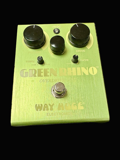 Green guitar effects pedal with 'Green Rhino' and 'Way Huge' branding on a textured surface.