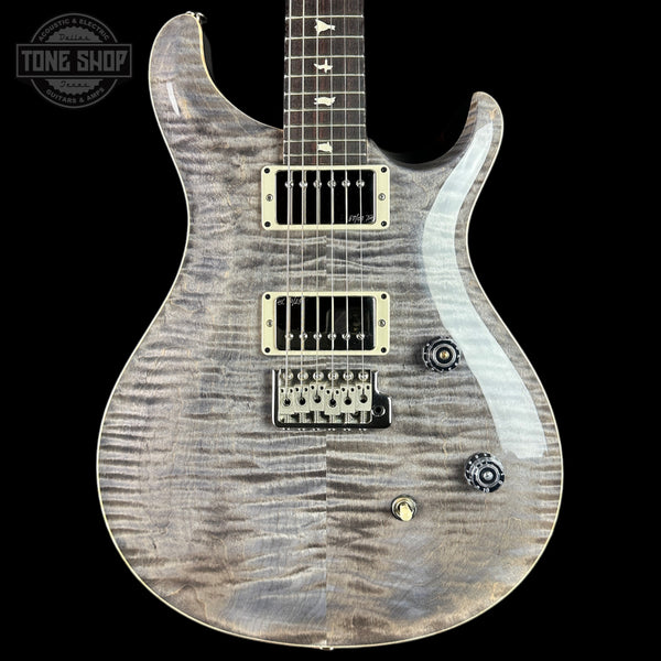 Electric guitar with a wood finish on a black background, featuring the Tone Shop logo.