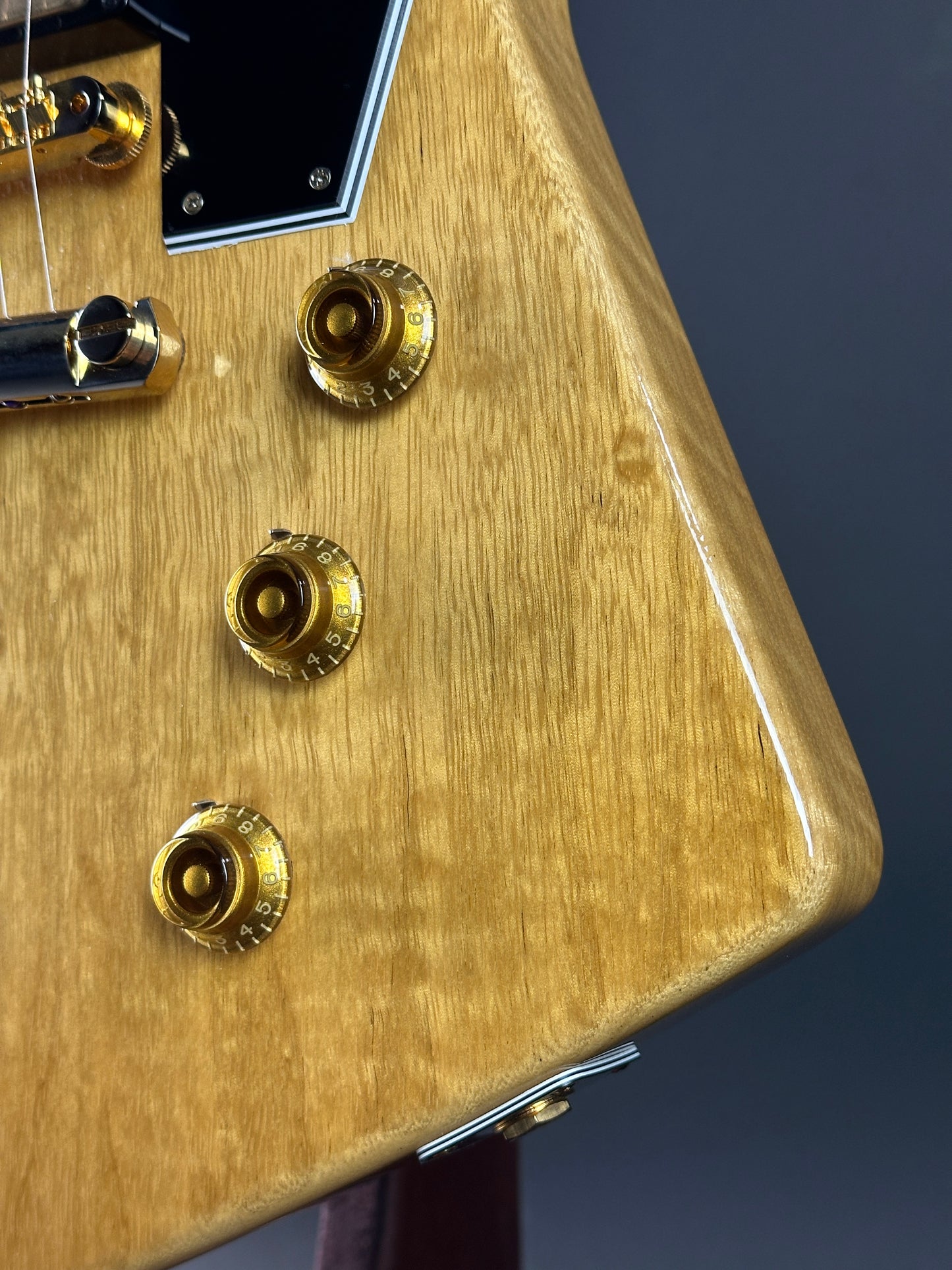 Close-up of a guitar's wood finish with gold hardware