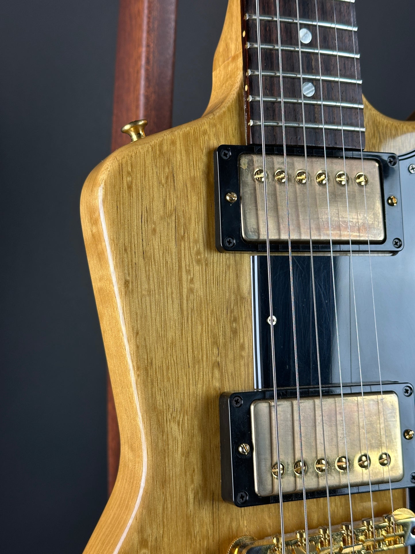 Close-up of a guitar's pickups and neck on a dark background