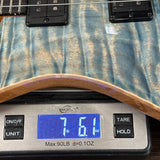 Close-up of a guitar body resting on a digital scale displaying 7.61 lbs, with the scale showing brand logo WeighJourney.