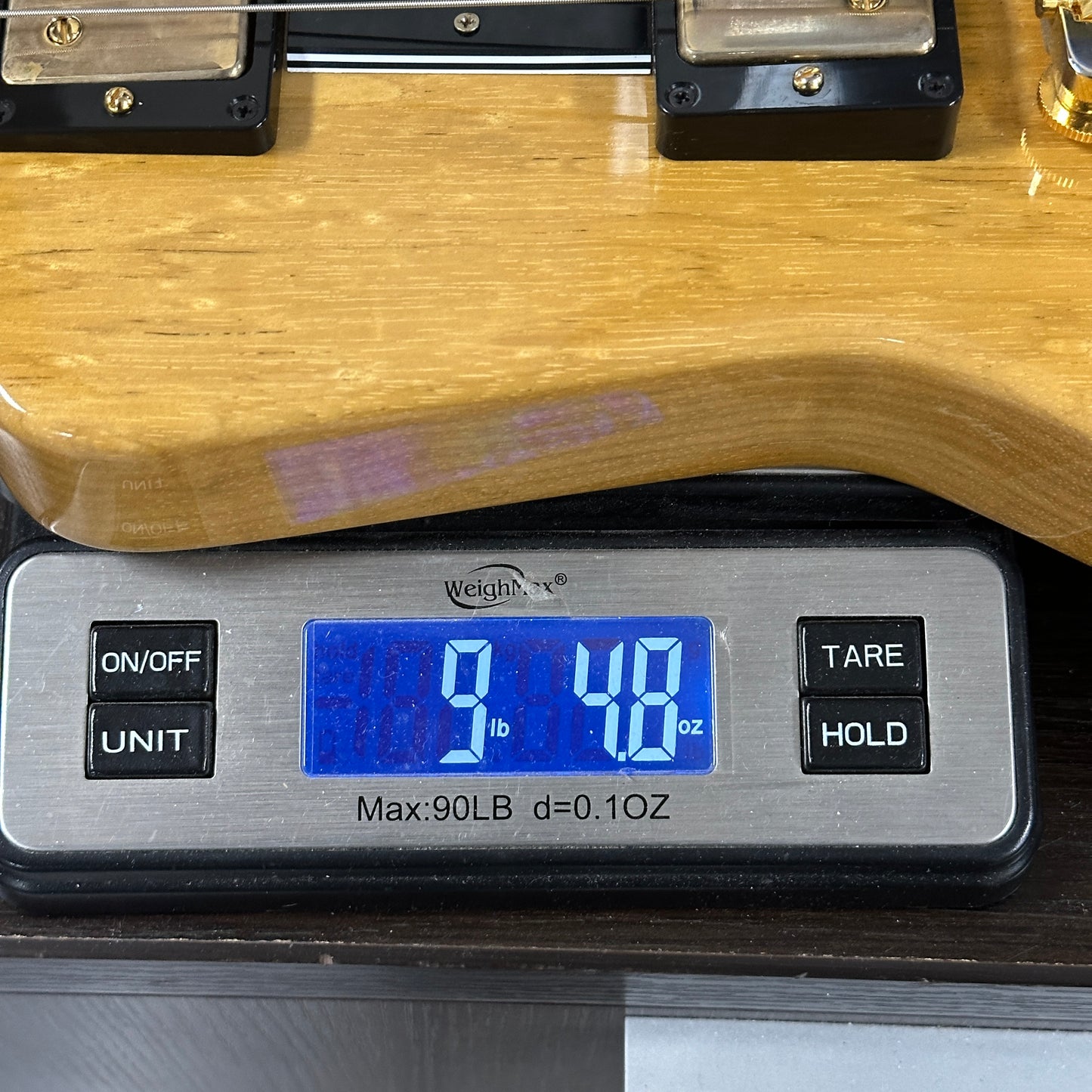 Digital scale displaying weight of a wooden object