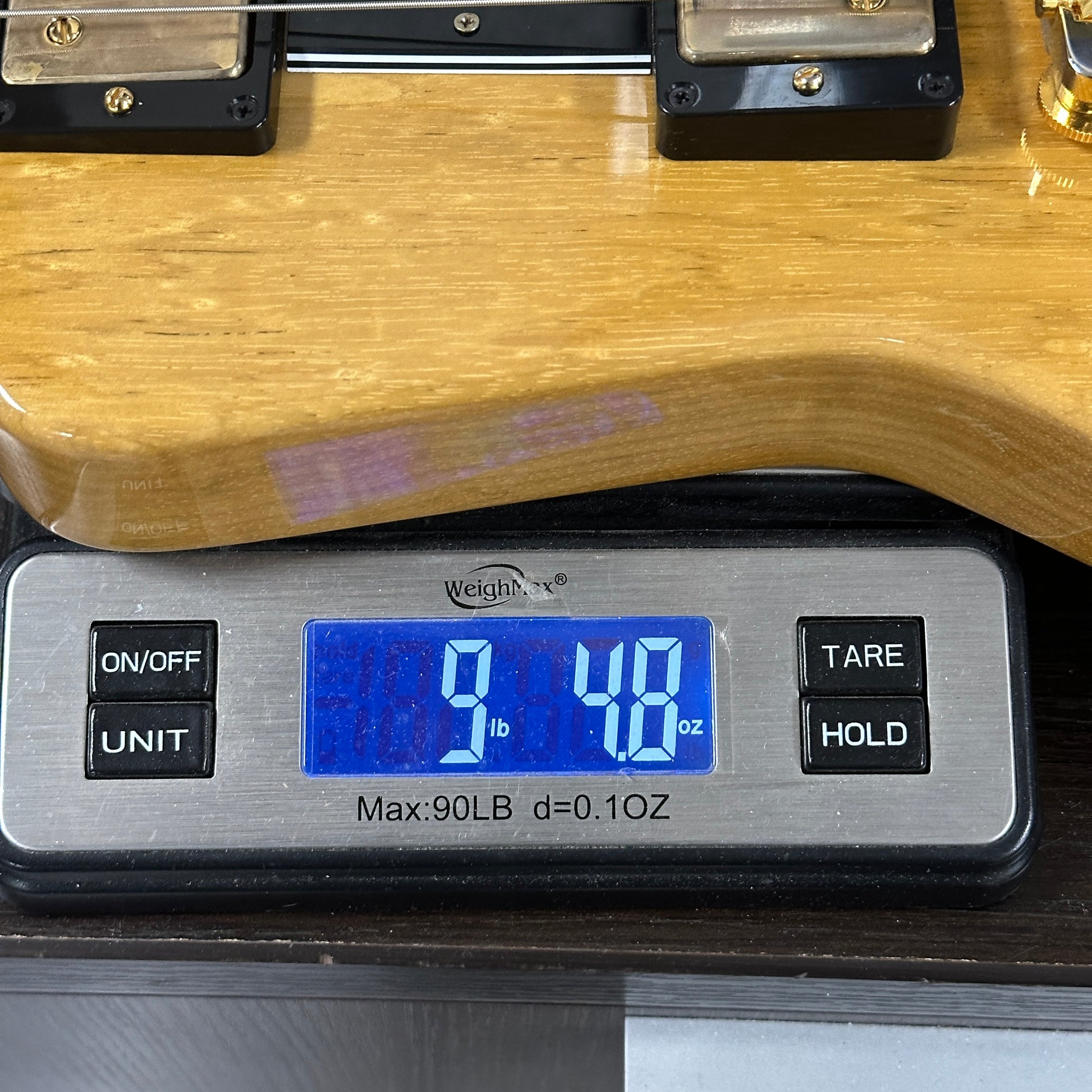 Digital scale displaying weight of a wooden object