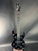 Black electric guitar with white patterns on a gray background