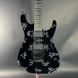 Black electric guitar with white patterns on a gray background