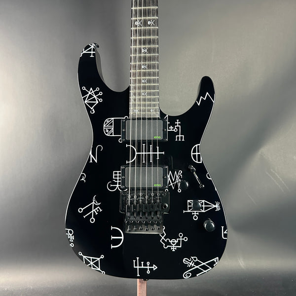 Black electric guitar with white patterns on a gray background