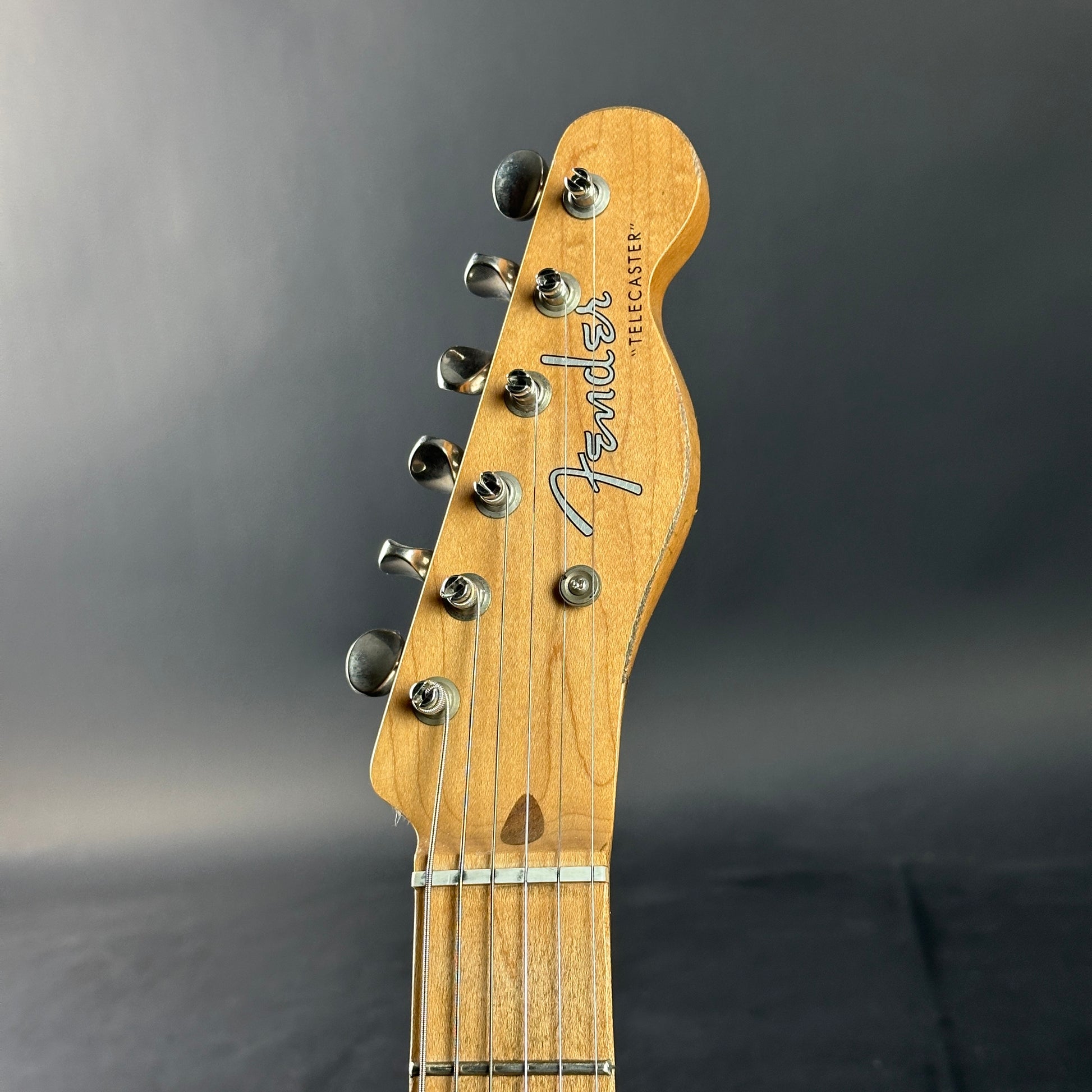 Fender electric guitar headstock on a gray background