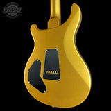 A gold metallic electric guitar body shown from the back against a solid black background, featuring black pickguard plates and a Tune Shop watermark in the upper left corner.