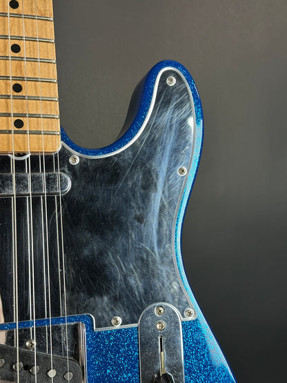 Close-up of a blue electric guitar with a black background