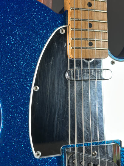 Close-up of a blue electric guitar with a focus on the neck and body.