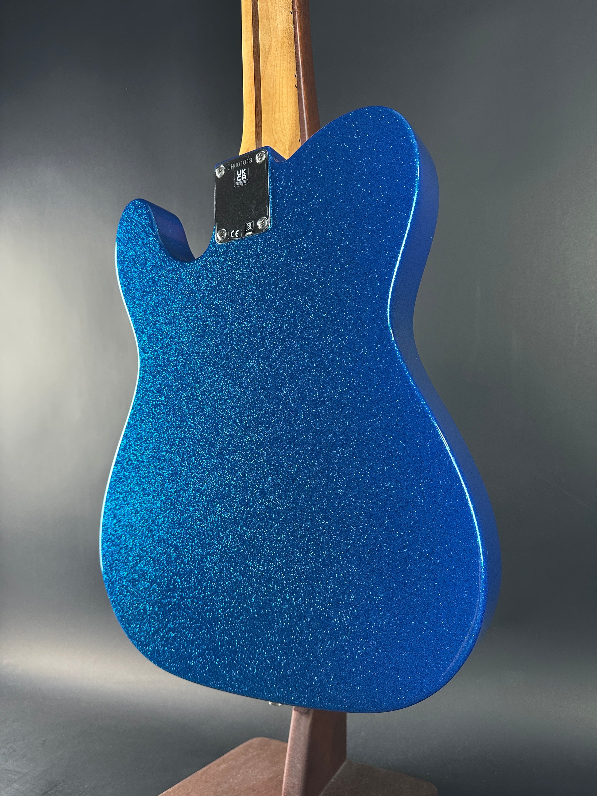 Blue glittery guitar body on a dark background