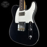 A black electric guitar with a white pickguard, chrome hardware, and a dark fretboard, shown against a black background with a Tone Shop watermark in the top left corner.
