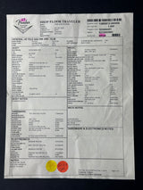 A crumpled white paper receipt or invoice sheet with printed text, barcodes, and two small colored stickers, photographed on a dark background.