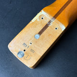 Close-up of a wooden object with metal screws on a dark background