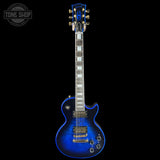 Blue electric guitar on a black background with 'Tone Shop' logo.