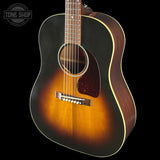 Acoustic guitar with a sunburst finish on a black background, featuring the Tone Shop logo.
