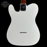 The back of a Fender Telecaster electric guitar body in white, featuring a black plate with gold hardware and a brown wood neck visible at the top, set against a solid black background.