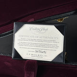 A framed C.F. Martin & Co. Certificate of Authenticity for a custom guitar, displayed inside an open dark red velvet case.