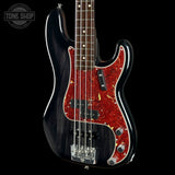 A black electric bass guitar with a red and gold maple wood pickguard, shown against a solid black background. A Tone Shop watermark is visible in the top left corner.