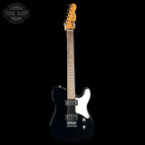 A black electric guitar with a white pickguard and maple neck, photographed against a solid black background. A Tone Shop watermark is visible in the top-left corner.