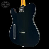 The back view of a black Fender Telecaster electric guitar, showing the glossy black body, silver hardware, and a portion of the natural wood neck against a black background.