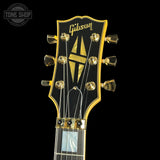 Gibson guitar headstock with brand logo on a black background