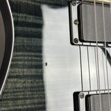 Close-up of a guitar's neck and headstock with a metallic finish.