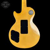 Yellow electric guitar body with a visible brand logo on a black background