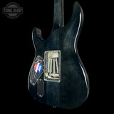 Black electric guitar with visible hardware on a black background, featuring 'Tone Shop' logo.
