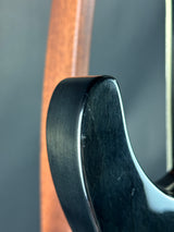 Close-up of a guitar pick with a wooden body and metal tip.
