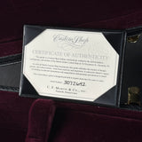 A black presentation case opened to reveal a Certificate of Authenticity insert from Martin Custom Shop. The insert features a white background with black text and a circular stamp, set against a dark burgundy velvet interior.