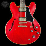 Red electric guitar with a black pickguard on a black background, featuring the 'Tone Shop' logo.