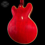 Red electric guitar body on a black background with 'Tone Shop' logo.